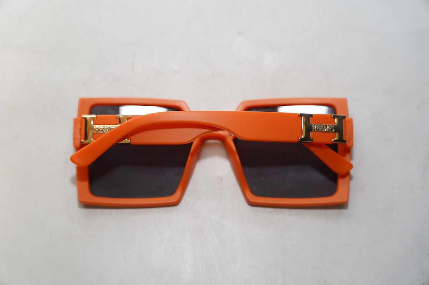 A pair of orange Hermes sunglasses